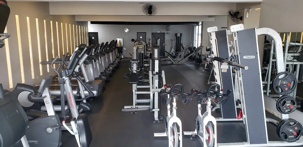 Aparelhos de cardio enfileirados ao lado das máquinas