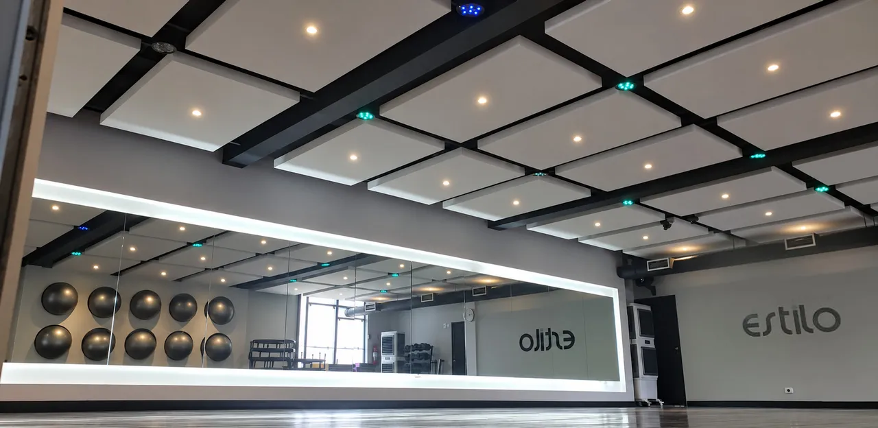 Sala fitness com espelho de parede inteira, bolas de exercício e o nome Estilo na parede